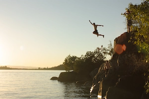 Cliff juping into crystal-clear waters from towering heights.